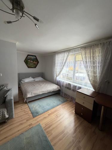 a bedroom with a bed and a window and a desk at Власний будинок in Rakhiv