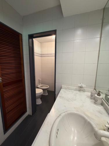 a bathroom with a tub and a toilet and a sink at LPR EZE Airport in La Unión