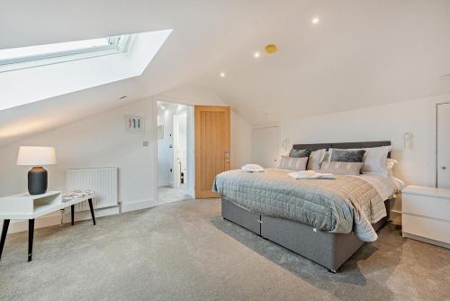 a white bedroom with a bed and a table at 6 Bed in Llanarthney oc-c28878 in Llanarthney