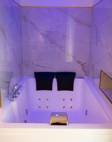 ein lila Badezimmer mit Badewanne und Waschbecken in der Unterkunft Sky Touch Suites Napoli in Neapel