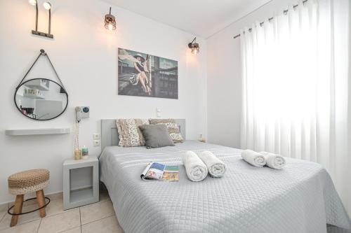 a white bedroom with a bed with towels on it at Naxos Diol in Naxos Chora