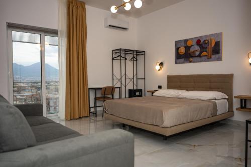 ein Schlafzimmer mit einem Bett und einer Couch in der Unterkunft Sky Touch Suites Napoli in Neapel