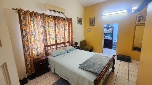 a bedroom with a bed and a large window at Elaine's Hideaway in Point Fortin