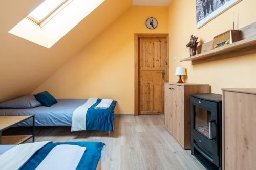a attic bedroom with a bed and a tv at Apartamenty Sawino 4 in Tykocin