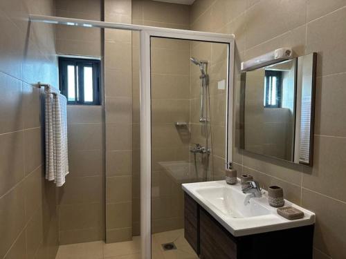 a bathroom with a sink and a shower at Villa EWA in Cotonou