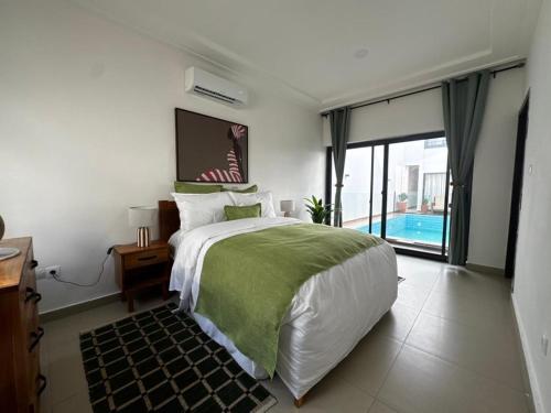 a bedroom with a large bed and a large window at Villa EWA in Cotonou