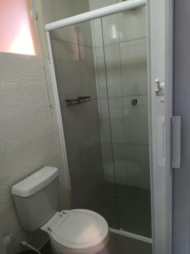 a bathroom with a toilet and a glass shower at Chalé do Mamute in Atibaia