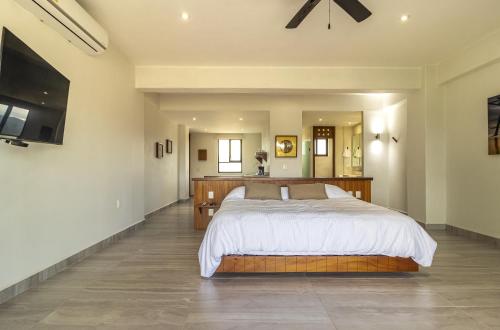 a bedroom with a large bed and a flat screen tv at El Secreto Residencial in Zihuatanejo