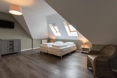 a attic bedroom with two beds and skylights at Luxe Duinvilla Stern met sauna voor 8 personen nabij strand en dorp Nes in Buren