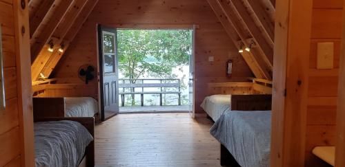 a room with two beds and a door with a window at Whitewater Cottage & RV Resort in Foresters Falls