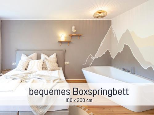 a bedroom with a bed and a bath tub at Alpenstudio Sachrang - Terrasse & Bergblick - Ruhe & Natur pur in Aschau im Chiemgau