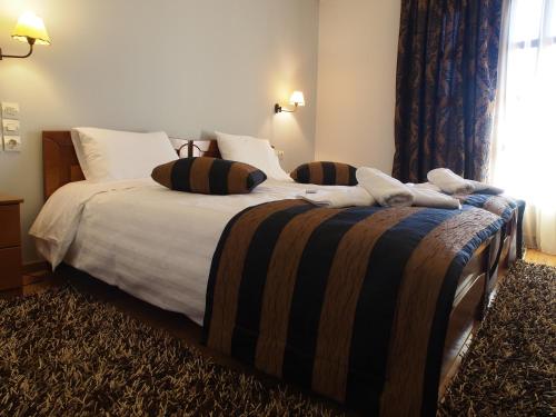 a bedroom with two beds with white sheets and a window at Archontiko Tzoumerkon in Agnanta