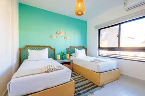 a bedroom with two beds and a blue wall at Elegant 3BD Condo in Cocotal in Punta Cana