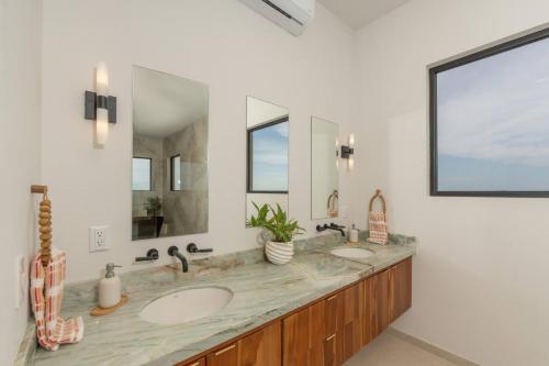 a bathroom with two sinks and two mirrors at NEW! Oceanview, Infinity Pool, Spacious & Private Luxury Group Retreat in Potrero
