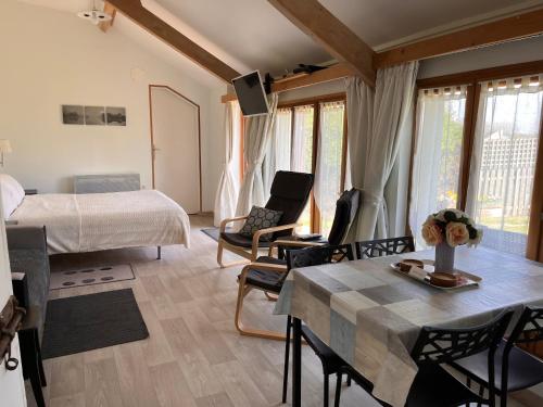 a bedroom with a bed and a table and chairs at Le Poirier Perfect for 2 adults and 2 children Heated Pool and Games Room in Auverse