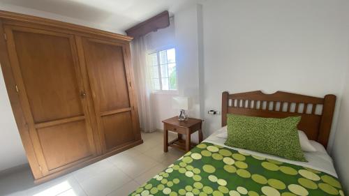 a bedroom with a bed with a green comforter at Casa Laura in Valle Gran Rey
