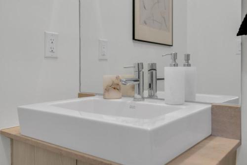 a bathroom with a large white sink with two faucets at Luxury Cityscape Condo in Toronto