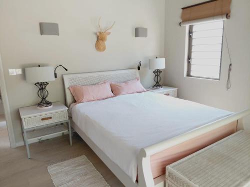 a bedroom with a large bed with pink pillows at Chamallow Nature Lodge in Grande Case Noyale
