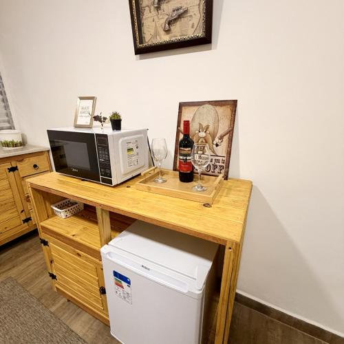 a microwave sitting on a wooden table with a refrigerator at Quarto Tema Praia - Top Country Ranch in Boituva