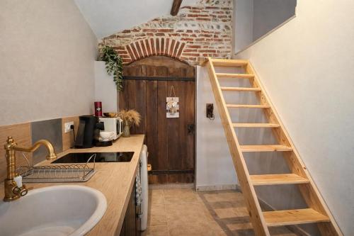 a bathroom with a sink and a staircase in front of a door at L'Amaryllis, suite romantique Jacuzzi et Parking in Cintegabelle