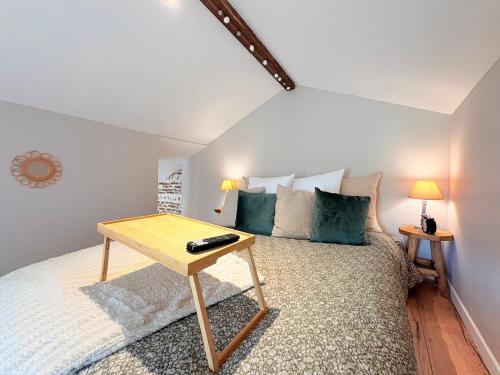a bedroom with a bed with a table on it at L'Amaryllis, suite romantique Jacuzzi et Parking in Cintegabelle