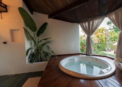 a large tub in a room with a window at AZORAI - Hotel Boutique in Santa Cruz Cabrália