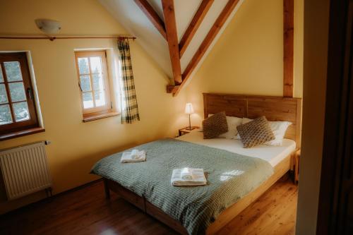 a bedroom with a bed with two towels on it at Chalupa Chudobka in Janske Lazne