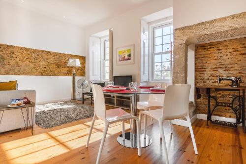 una sala da pranzo e un soggiorno con tavolo e sedie. di São Mamede Downtown Apartment a Lisbona