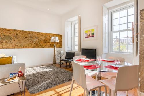 a living room with a glass table and chairs at São Mamede Downtown Apartment in Lisbon