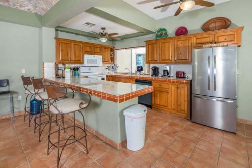 a kitchen with wooden cabinets and a stainless steel refrigerator at Spacious Beachfront Condo Las Palmas II 11A in Puerto Peñasco