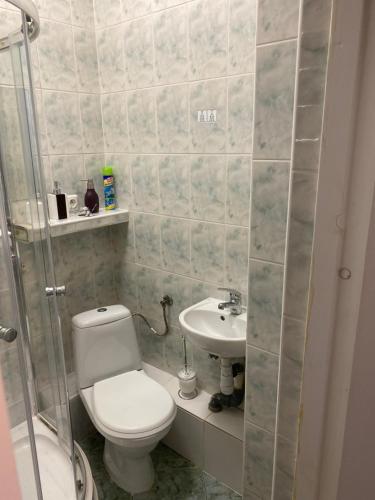 a bathroom with a toilet and a sink at Mossmarken Stay in Warsaw