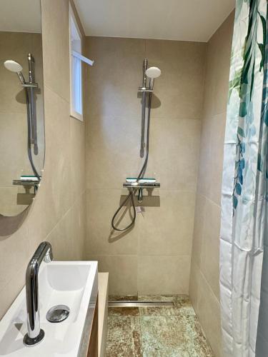 a bathroom with a sink and a shower at Tiny Beachhouse Noordwijk in Noordwijk