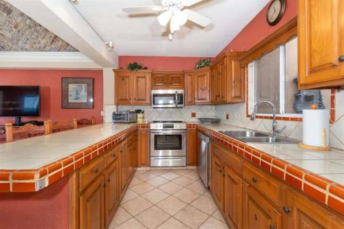 a kitchen with wooden cabinets and a counter top at Comfortable Beachfront Condo Las Palmas II 11 B in Puerto Peñasco