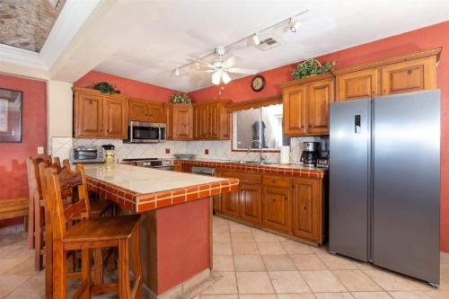 a kitchen with wooden cabinets and a stainless steel refrigerator at Comfortable Beachfront Condo Las Palmas II 11 B in Puerto Peñasco