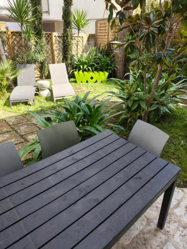 a wooden picnic table and chairs in a garden at BariMetro Garden in Capurso