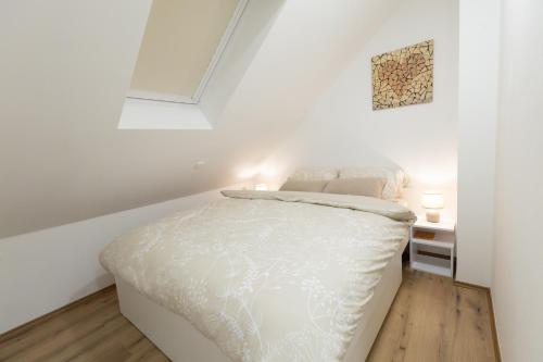 a bedroom with a white bed in a white room at Apartman ''Kod bake'' Delnice biker-friendly in Delnice
