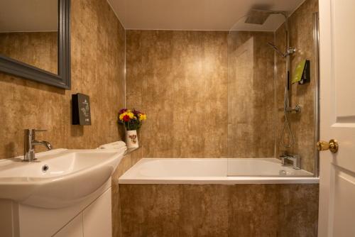ein Badezimmer mit Waschbecken und Badewanne in der Unterkunft George Hotel in Hexham