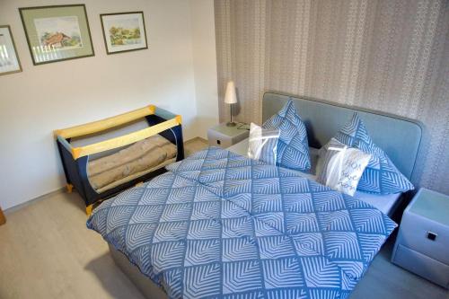 a bedroom with a bed with a blue and white comforter at Ruhiges Apartment am Stadtrand in Kevelaer