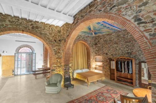 a room with a brick wall with a bed and a table at Garibaldi Art Apartment in Piombino