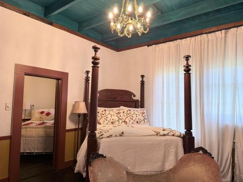 a bedroom with a bed with a chandelier and a mirror at The Courtableau Cottage in Washington