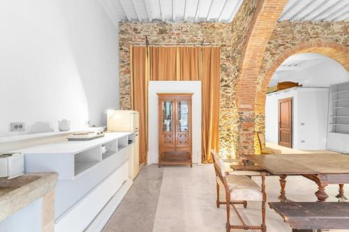 a kitchen with a table and a brick wall at Garibaldi Art Apartment in Piombino