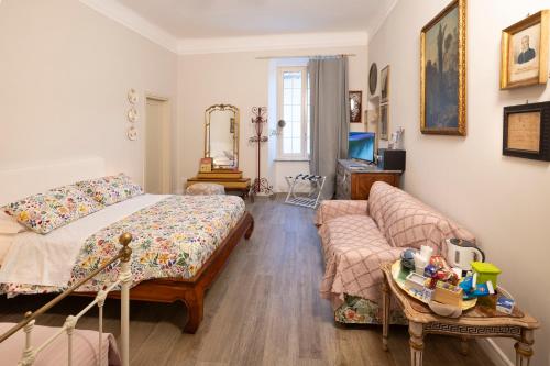 a bedroom with a bed and a couch at La Dimora di B.Cairoli in Ovada