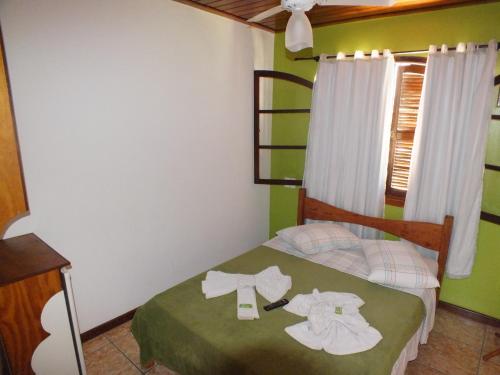 een kleine slaapkamer met een bed met handdoeken erop bij Pousada Arco Íris in Abraão