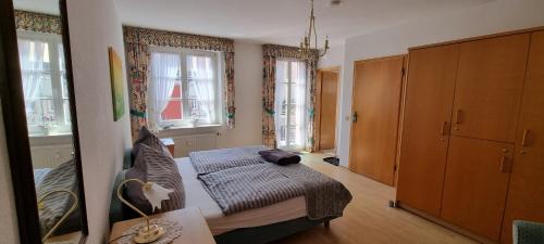 a bedroom with a bed and a couch and windows at Hotel Haus Irsfeld in Waxweiler