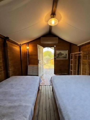 two beds sitting in a room with a door at Adrasan Camping in Kumluca