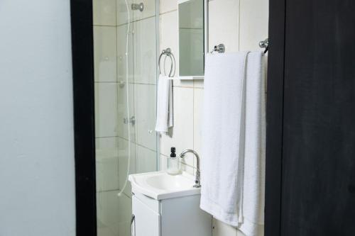 a bathroom with a sink and a mirror at Quitinete Moderna Centro Loft Studio Inteligente 5 in Presidente Prudente