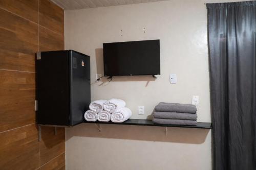 a bathroom with a shelf with towels and a tv at Aguas de Alter in Santarém