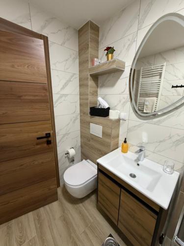 a bathroom with a toilet and a sink and a mirror at PRESTIGE studio Krusevac in Kruševac