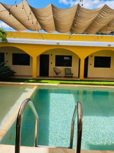 a swimming pool in front of a house at Hotel Villa Chucum in Valladolid