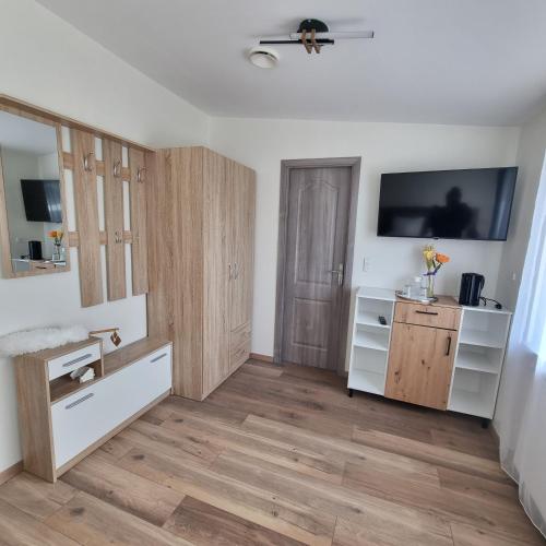 a living room with wooden floors and a tv on the wall at Karlskovhuset in Give